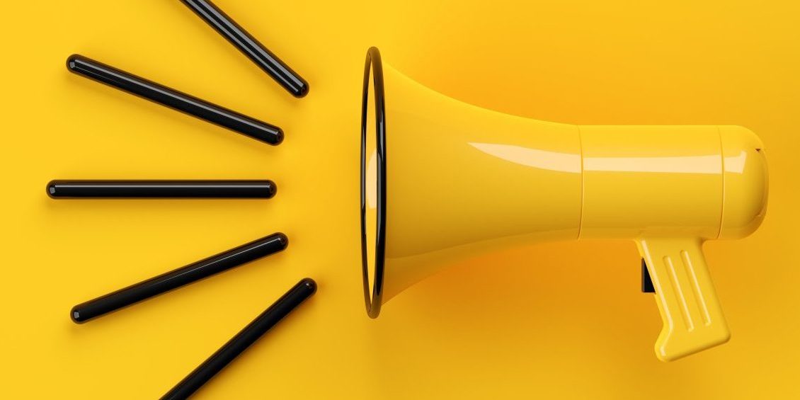 Yellow megaphone or bullhorn with lines over yellow background,